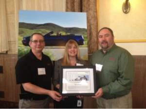 Doug Winfrey (izquierda) y yo (derecha) aceptamos el premio Quality Excellence Award 2014 de Webasto entregado por el comprador de Webasto, Dawn Bostwick